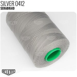 May include: A spool of gray thread with a green end cap. The label on the spool reads "SILVER 0412 SERABRAID".