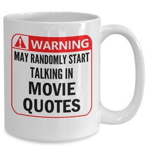 Op de afbeelding: Witte keramische mok met een gebogen handvat. De mok heeft een rood en wit waarschuwingslabel met de tekst "WARNING MAY RANDOMLY START TALKING IN MOVIE QUOTES" in zwarte tekst. De mok is ontworpen voor filmliefhebbers.