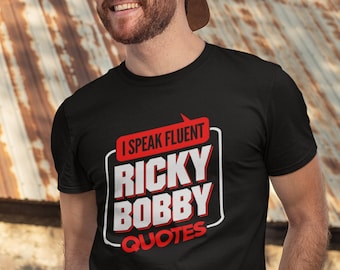 May include: Black t-shirt with a white graphic that says "I speak fluent Ricky Bobby Quotes" in a red box.