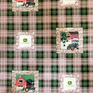 May include: Green, brown, and pink plaid fabric with a repeating pattern of a red barn, a green tractor, and the words "John Deere".