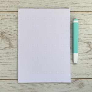May include: A white sheet of paper with a grid of small dots. A light blue highlighter is next to the paper.