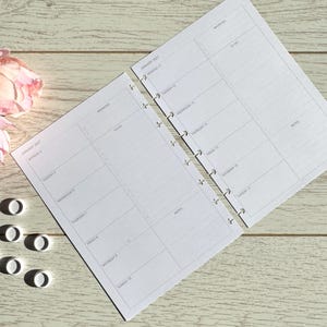 May include: A white paper planner insert with two pages showing January 2027. The layout includes sections for priorities, to-do lists, and notes for each day from Monday the 4th to Sunday the 17th. Several small white plastic binding discs are visible.