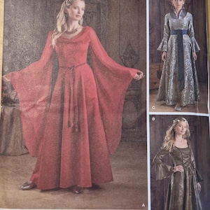 Könnte beinhalten: Simplicity Schnittmuster 1045 mit Kleidern im mittelalterlichen Stil. Das Hauptbild zeigt ein rotes Kleid mit langen, fließenden Ärmeln. Zusätzliche Kleiderdesigns sind in Silber und Braun dargestellt.
