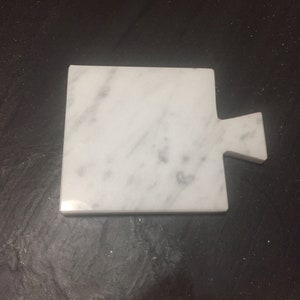 12x10x1 white carrara marble coasters in the shape of a chopping board with the possibility of having it in other colors and shapes.