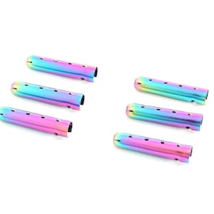 Puede incluir: Seis aglets metálicos iridiscentes en un esquema de colores arcoíris. Los aglets miden aproximadamente 5 cm de largo y tienen un extremo redondeado.