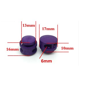 Puede incluir: Dos cierres de cord&oacute;n de pl&aacute;stico morado con medidas en mil&iacute;metros. El cierre de cord&oacute;n de la izquierda tiene 16 mm de ancho, 13 mm de alto y 6 mm de grosor. El cierre de cord&oacute;n de la derecha tiene 17 mm de ancho, 10 mm de alto y 6 mm de grosor.