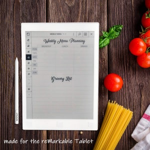 Pu&ograve; includere: Un e-reader bianco con uno schermo grigio che mostra un pianificatore di menu settimanale con sezioni per la colazione, il pranzo e la cena. Lo schermo include anche una sezione di lista della spesa. L'e-reader &egrave; su una superficie di legno con un grappolo di pomodori, un rametto di basilico e un fascio di spaghetti.