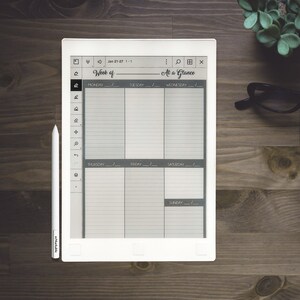 Pu&ograve; includere: Un e-reader bianco con uno stilo nero e grigio. Lo schermo mostra un planner settimanale con il testo "Week of" e "At a Glance". Le date sono "Jan 21-27 1-1".