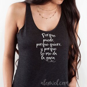 May include: A dark gray tank top with a white graphic that reads "Porque puedo, porque quiero, y porque se me da la gana."