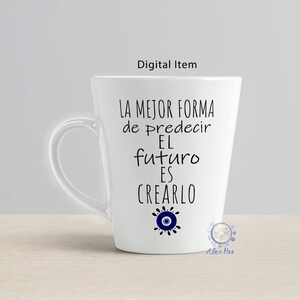 May include: White ceramic mug with a black and blue design. The mug features the text "La mejor forma de predecir el futuro es crearlo" and a blue evil eye symbol.