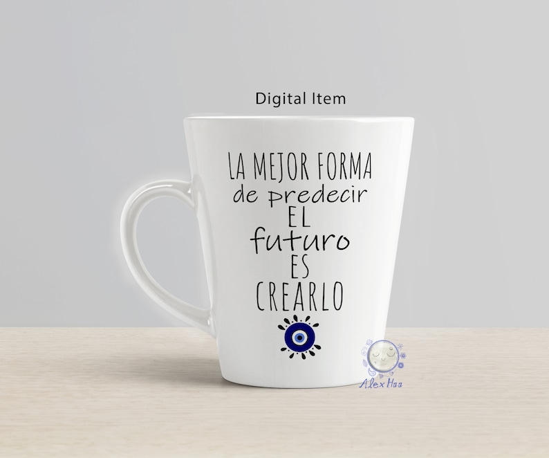 May include: White ceramic mug with a black and blue design. The mug features the text "La mejor forma de predecir el futuro es crearlo" and a blue evil eye symbol.