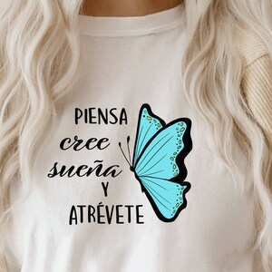 May include: White t-shirt with a blue butterfly graphic and the text "PIENSA cree sue&ntilde;a y ATR&Eacute;VETE" in black.