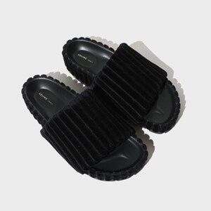 May include: A pair of black velvet slides with a ridged texture and the text "CELINE PARIS" on the insole.