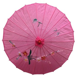 May include: A pink paper parasol with a floral and dragonfly design. The parasol is closed and has a wooden handle.