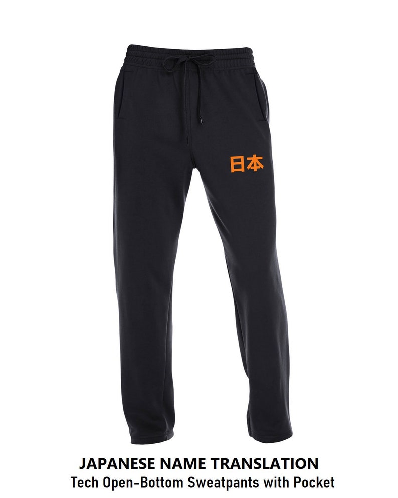May include: Black sweatpants with an orange Japanese word "日本" (Japan) printed on the left leg. The sweatpants have a drawstring waistband and a pocket on the left side.