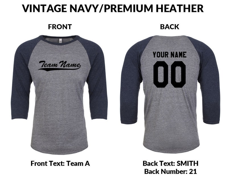 May include: A baseball style t-shirt in a navy blue and heather grey colour scheme. The front of the shirt features the text "Team Name" in a black script font. The back of the shirt has the text "YOUR NAME" in black block letters above the number "00" in black block letters.