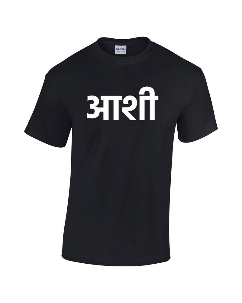 May include: Black t-shirt with the word "आशी" printed in white on the front.