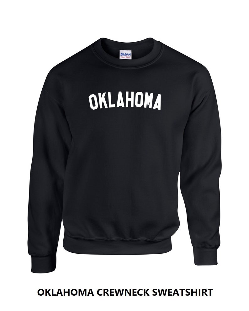 May include: Black crewneck sweatshirt with the word "OKLAHOMA" printed in white on the front.