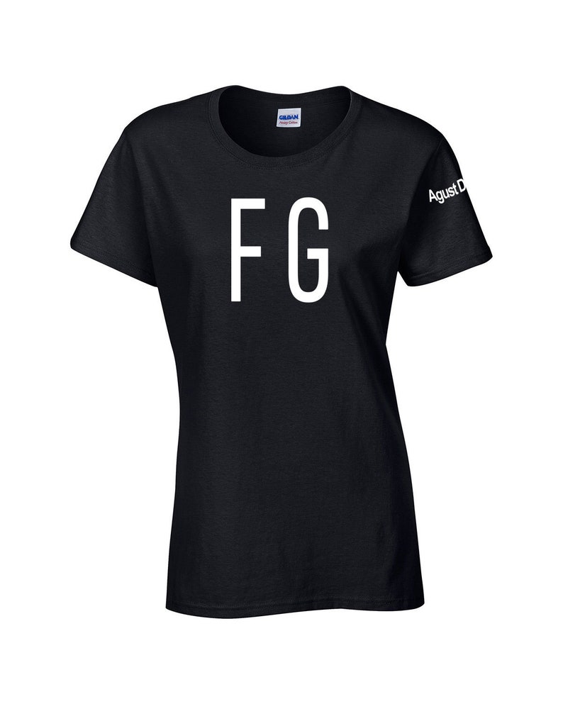 Puede incluir: Camiseta negra con las letras blancas "FG" impresas en la parte delantera. La manga tiene el texto "Agust D" impreso en blanco. La camiseta est&aacute; hecha de un material suave.