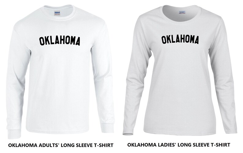 May include: Two white long-sleeve t-shirts with the word "OKLAHOMA" printed in black on the front. The shirt on the left is labeled "OKLAHOMA ADULTS' LONG SLEEVE T-SHIRT" and the shirt on the right is labeled "OKLAHOMA LADIES' LONG SLEEVE T-SHIRT".