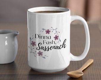 May include: White ceramic mug with a floral design and the text "Dinna Fash, Sassenach".