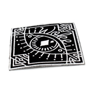 May include: Black and white embroidered patch with a stylized eye design. The eye is surrounded by geometric shapes and lines.
