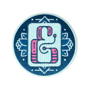 May include: An embroidered patch featuring a stylised number "8" in pink and blue. The number is surrounded by a decorative border with geometric shapes.