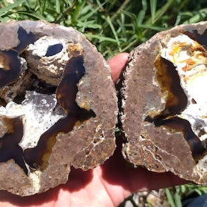 Könnte beinhalten: Zwei Hälften eines Geoden mit braunen, weißen und gelben Achatkristallen. Der Geode ist halbiert und zeigt das Innere des Gesteins.