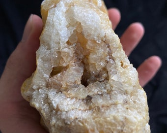 Roccia di calcedonio arancione con cristalli di quarzo e foro naturale