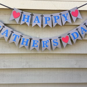 May include: A gray banner with blue letters that reads "Happy Father's Day" with red hearts between the words.