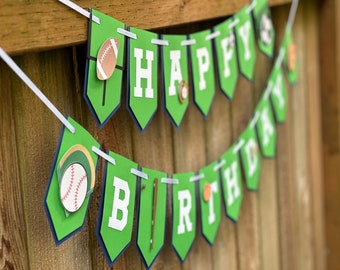 May include: Green and blue pennant banner with the words "Happy Birthday" and sports-themed decorations.