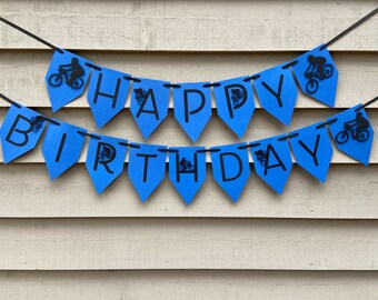 May include: Blue and black banner with the words "Happy Birthday" and a silhouette of a person riding a bicycle on each flag.