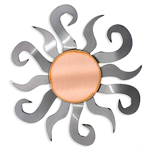 May include: A metal sun wall decor with a copper center. The sun has a stylized design with 12 rays that curl at the ends.