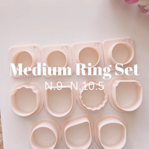 May include: A set of nine plastic ring cutters in various sizes, ranging from 9 to 10.5 inches. The cutters are arranged in a grid pattern on a white surface. The text "Medium Ring Set N.9 - N.10.5" is printed below the cutters.
