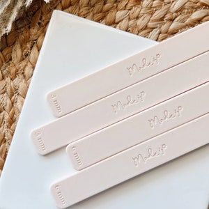 Peut inclure: Quatre spatules en silicone rose avec le mot "Make It" gravé sur chacune. Les spatules sont étiquetées avec des mesures en millimètres : 3 mm, 3 mm, 6 mm et 6 mm.