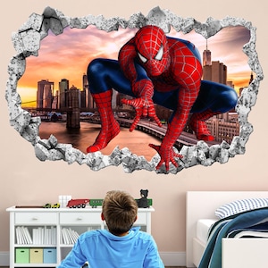 May include: A red and blue Spiderman wall decal with a 3D effect, showing Spiderman crawling out of a cracked wall. The decal is set against a backdrop of a cityscape with a sunset sky.