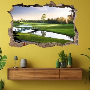 Pode incluir: Um adesivo de parede 3D que representa um campo de golfe com uma ponte sobre um lago. A cena se passa em uma paisagem verde exuberante com um céu azul brilhante e um sol brilhando à distância.