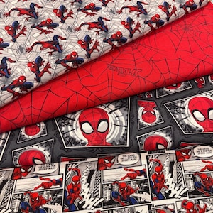 Może przedstawiać: Cztery warstwy bawełnianej tkaniny z motywami Spider-Mana. Wzory obejmują Spider-Mana w różnych pozach na tle pajęczyny, czerwoną tkaninę z czarnymi pajęczynami i logo Spider-Mana, szary nadruk komiksowy oraz czarno-biały pasek komiksowy.