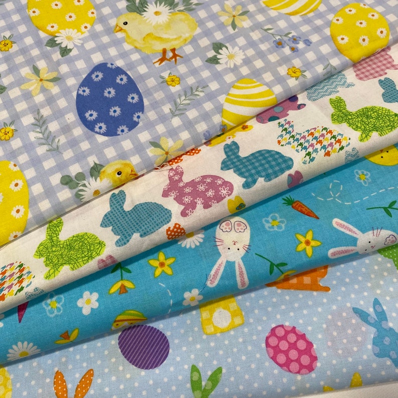 Puede incluir: Cuatro patrones de tela diferentes con temas de Pascua. Los patrones incluyen vichy azul y blanco, blanco con conejos y huevos coloridos, azul con lunares blancos y conejos, y blanco con pollitos y huevos coloridos.
