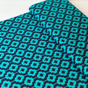 May include: Teal and navy blue fabric with a repeating geometric pattern. The fabric is folded in half, showing the pattern on both sides.