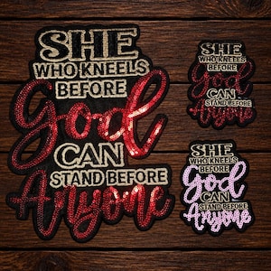 Puede incluir: Tres parches bordados con el texto "SHE WHO KNEELS BEFORE GOD CAN STAND BEFORE ANYONE". El parche más grande tiene lentejuelas rojas en "God" y "Anyone" con letras doradas. Los parches más pequeños tienen detalles de lentejuelas rojas y rosas.