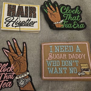 Może przedstawiać: Biały ceramiczny kubek z czarnym uchwytem i napisem "But First, Coffee" pogrubioną czcionką. Kubek jest umieszczony na neutralnym tle, podkreślając jego prosty design.