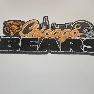Può includere: Toppa ricamata con le parole "Chicago Bears" in lettere nere con dettagli arancioni. La toppa include una testa di orso, un casco da football americano e una silhouette dello skyline.