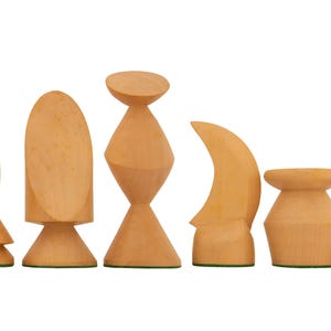 May include: A set of six wooden chess pieces in various shapes. The pieces are light brown with green bases, and include a bishop, rook, queen, knight, and king.