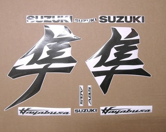 May include: A set of black and white motorcycle decals with a carbon fiber pattern. The decals feature the word "Suzuki" and the text "Hayabusa".