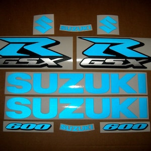 Könnte beinhalten: Ein Satz blauer und silberner Motorradaufkleber mit den Worten "GSX", "SUZUKI" und "600".