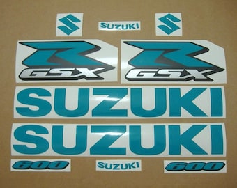 May include: Teal and silver Suzuki GSX 600 motorcycle decals. The decals include the Suzuki logo, GSX, and 600.