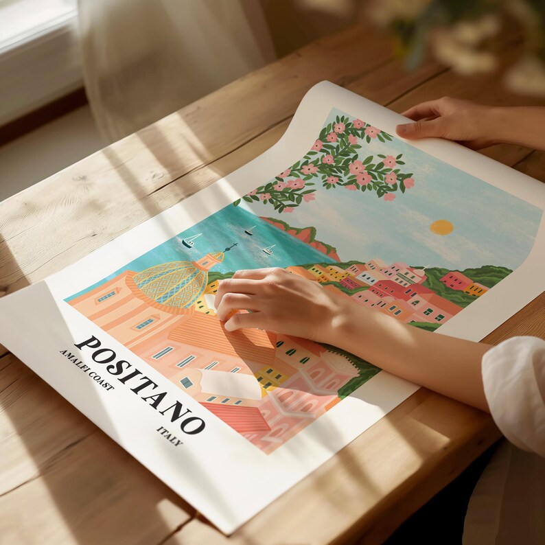 Puede incluir: Un p&oacute;ster ilustrado colorido con el texto "Positano, Amalfi Coast, Italy". El p&oacute;ster presenta una vista de la ciudad de Positano con edificios, una c&uacute;pula y un &aacute;rbol en flor.
