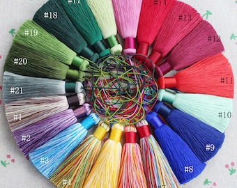 May include: A collection of 21 colorful tassel ornaments, arranged in a circle. Each tassel is numbered from 1 to 21. The tassels are made of various colors, including red, green, blue, yellow, and purple.