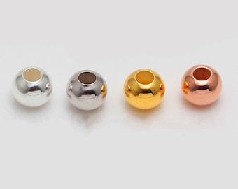 May include: Four round metal beads in different colours: silver, grey, gold, and rose gold. The beads have a hole in the centre for stringing.